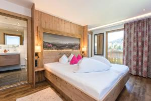 a bedroom with a large white bed with pink pillows at Haus Alpenrose in Serfaus