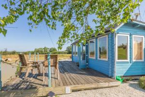 a blue tiny house with a bench on a deck at 1 Bed in Beaworthy oc-93267 in Ashwater