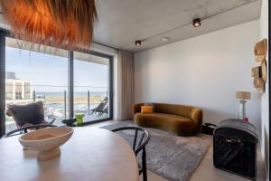 a living room with a table and a view of the ocean at Suite O in Ostend