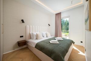 a bedroom with a large white bed with a window at Golf Park Rajszew in Rajszew