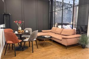 a living room with a couch and a table and chairs at Deco Apartments Mariacka 8 - apartamenty w centrum Katowic in Katowice