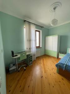 an empty room with a desk and a bed at JB Dubendi house in Baku