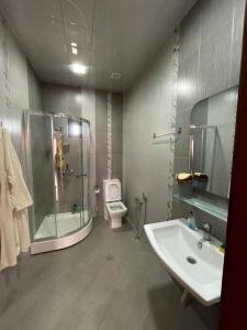 a bathroom with a shower and a sink and a toilet at JB Dubendi house in Baku +9 photos