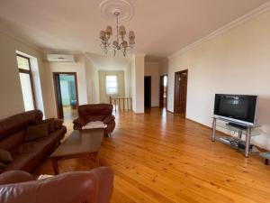 a living room with a couch and a flat screen tv at JB Dubendi house in Baku
