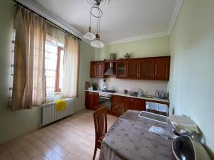 a kitchen with wooden cabinets and a table in it at JB Dubendi house in Baku
