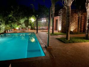 a swimming pool in a yard at night at Villa Malika Private Luxury Villa Marrakech in Tameslouht