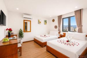 a hotel room with two beds and a television at Merry Land Hotel Da Nang in Danang +43 photos