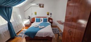 a bedroom with a bed with blue sheets and blue pillows at Motel Buti in Sighetu Marmaţiei
