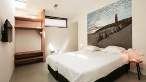 a bedroom with a bed and a painting on the wall at Dutchen Park Duynzoom in De Koog