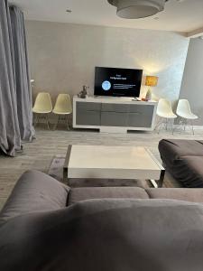 a living room with a couch and a flat screen tv at Spacieuse et agréable à séjourner in Garges-lès-Gonesse