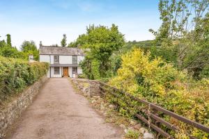 a dirt road in front of a white house at 2 Bed in Llangynidr oc-l31914 in Llangynidr