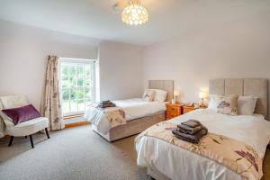 a bedroom with two beds and a chair and a window at 2 Bed in Llangynidr oc-l31914 in Llangynidr