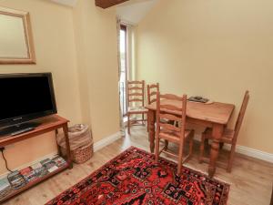 a living room with a table and chairs and a television at The Hayloft in Wigton +12 photos