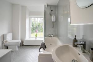 a white bathroom with a tub and a toilet at 2 Bed in Llangynidr oc-l31914 in Llangynidr +33 photos