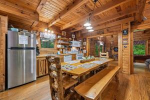 a kitchen with a table and a refrigerator at A Rustic Elegance #4 by Venture Smoky Mountains in Sevierville