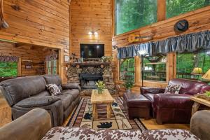 a living room with leather furniture and a fireplace at A Rustic Elegance #4 by Venture Smoky Mountains in Sevierville