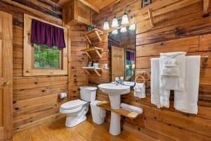 a log cabin bathroom with a toilet and a sink at A Rustic Elegance #4 by Venture Smoky Mountains in Sevierville +78 photos