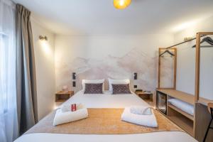 a bedroom with a large bed with two pillows at Logis Hotel de l'Artuby in Séranon
