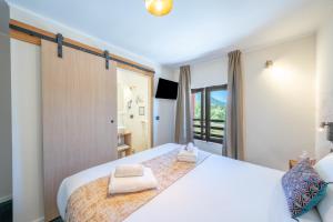 a bedroom with a large white bed with towels on it at Logis Hotel de l'Artuby in Séranon