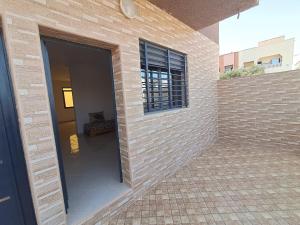 a building with a brick wall and a window at Résidence Maya 1 près de la plage in Ras El Ma