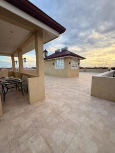 a large patio with a table and a house at Lumiere Suites in Georgetown