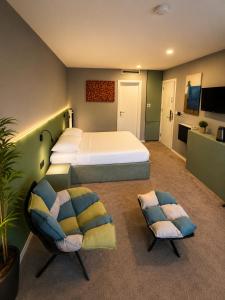 a bedroom with a large bed and two chairs at Boutique Hotel Bora in Peje