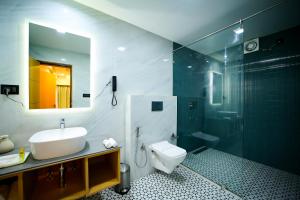 a bathroom with a sink and a toilet and a shower at Surya Garden in Tālcher +17 photos
