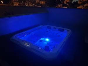 a blue bathtub with a light in the dark at Suites appartement 1 chambre & Spa in Montauban