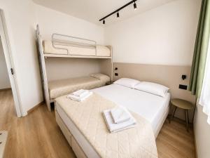 a small room with two beds and a bunk bed at Residenza Sant'Antonio - Sottomarina in Sottomarina