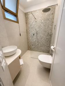 a bathroom with a shower and a toilet and a sink at Residenza Sant'Antonio - Sottomarina in Sottomarina +28 photos