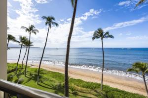 a view of a beach with palm trees and the ocean at SUGAR BEACH RESORT, #421 in Kihei