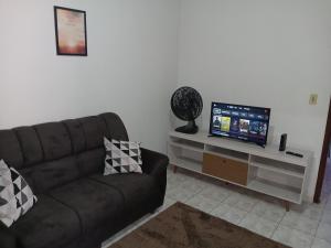 a living room with a couch and a flat screen tv at casa de temporada Império 1 in Olímpia