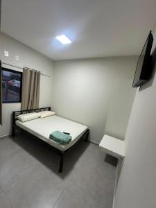 a small room with a bed and a television at Center in Uberlândia
