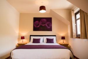 a bedroom with a large bed with purple pillows at The Galleries No 3 in Spean Bridge