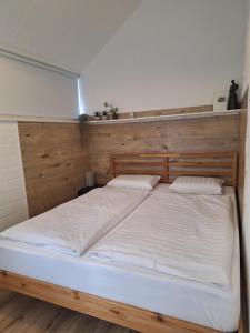 a large bed with a wooden headboard in a room at Rekerlanden 117 in Schoorldam