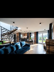 a living room with a blue couch and a staircase at Family Resort Ustka - Domki dwupoziomowe z basenem , sauna , balia in Ustka