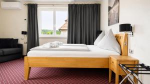 a bedroom with a large bed and a window at Hotel Leitner in Kaufbeuren