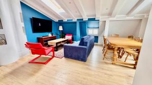 a living room with a blue accent wall and a table and chairs at Sopot Przy Plaży in Sopot