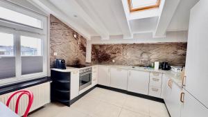 a kitchen with white cabinets and a large window at Sopot Przy Plaży in Sopot +13 photos