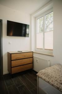 a bedroom with a dresser with a flat screen tv on the wall at Villa Medicus in Dessau