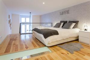 een slaapkamer met een groot bed en een bakstenen muur bij Modern Loft in Bica -JJ Apartment's in Lissabon