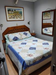 a bedroom with a bed with a quilt and a mirror at NEW Hotel Casa del Profesor in Iquique