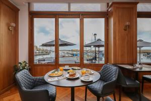 a dining room with a table and chairs and a window at Porto Veneziano Hotel in Chania