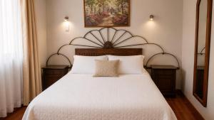 a bedroom with a large white bed with two pillows at NEW Hotel Casa del Profesor in Iquique