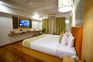 a hotel room with a bed and a tv at Surya Garden in Tālcher