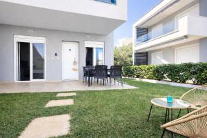 a patio with chairs and a table in a yard at Eliza Meraki in Ofrínion