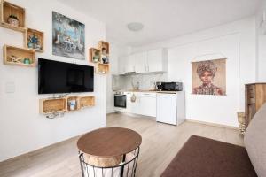 a living room with a table and a kitchen at Eliza Meraki in Ofrínion