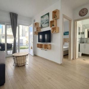 a living room with a flat screen tv on a wall at Eliza Meraki in Ofrínion