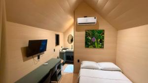 a small room with a bed and a tv at Hotel Terra do Sal in Mossoró