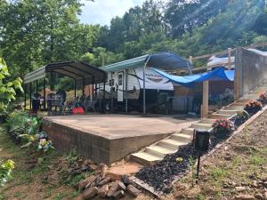 an rv under a tent in a yard at Camper with Queen and bunk bed in Robbinsville